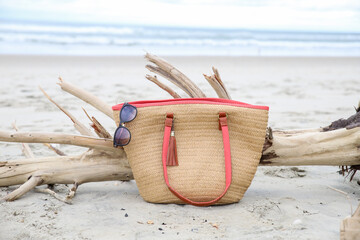 A woven beach bag and sunglasses on the beach of Ocracoke, NC