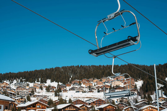 Ski lift chair with chalet roofs in the background