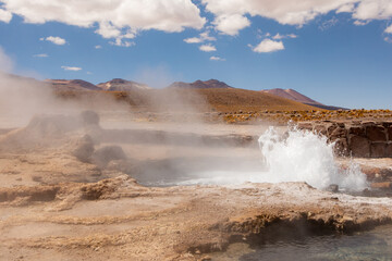 Tatio Geyser, Atacama Desert, Chile. Geyser steam in the desert with blue sky and clouds.