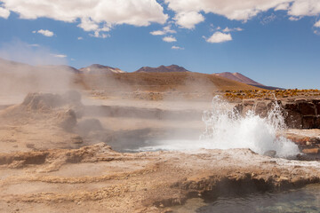Tatio Geyser, Atacama Desert, Chile. Geyser steam in the desert with blue sky and clouds.