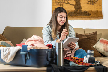 Young woman organising her suitcase before a trip.