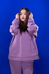 Young girl posing and moving on a blue background	