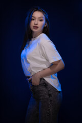 Young girl posing and moving on a blue background	