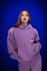 Fototapeta premium Young girl posing and moving on a blue background 