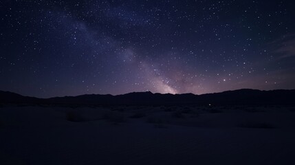 Naklejka premium Stunning night sky with millions of stars and the Milky Way stretching over a dark valley. Captured with long exposure, showcasing the vast cosmos, glowing nebulae, and infinite celestial beauty.