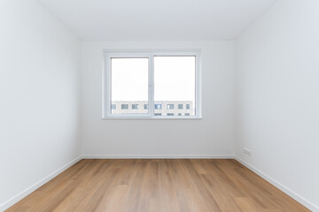 interior empty basic bedroom in modern new build residential smart house. Glass window is neighboring building over the road. Plain white walls and wood effect vinyl flooring make blank canvas