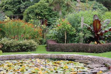 Colourful flower beds and a pond in a garden in summer