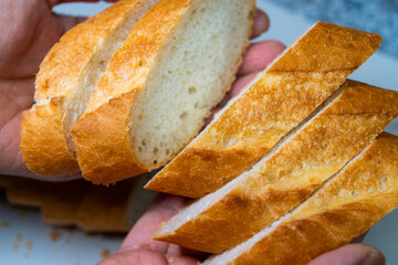 Slice of baguette bread on the hand