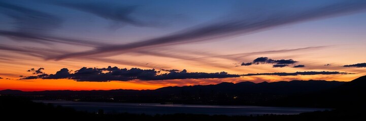 Naklejka premium Salt Lake City skyline silhouette against colorful dusk sky, with mountains in background, landscape, sunset, clouds