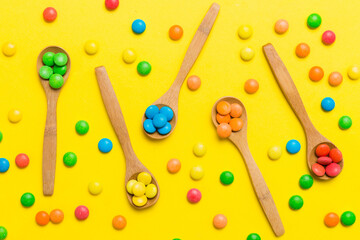 delicious colorful sweet candies on spoon on colored background . Confectionery decor top view with copy space