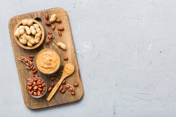 Bowl of peanut butter and peanuts on table background. top view with copy space. Creamy peanut...