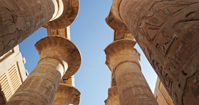 Up view slow motion between the stone pillars of Luxor temple, Egypt