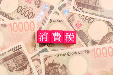 一万円札とブロックの上に書かれた消費税　経済