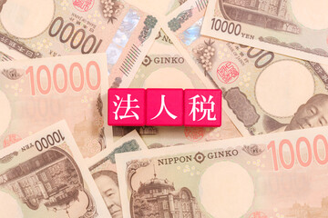 一万円札とブロックの上に書かれた法人税　経済