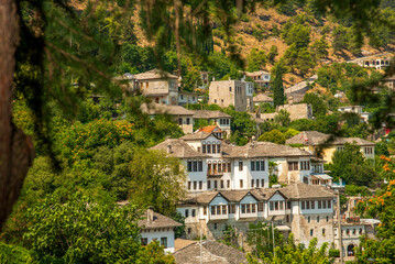 Fototapeta premium Enchanted Hillsides of Gjirokaster: Albania’s Historic Ottoman-Era Stone City Overlooking Verdant Slopes and the Drino Valley’s Balkan Legacy