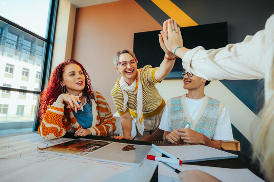 Energetic teacher high-fiving students in a high school classroom promoting teamwork and motivation