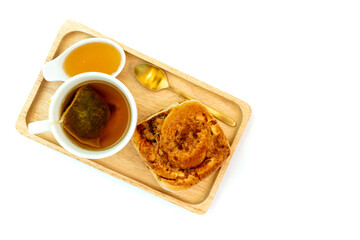 Hot tea and honey with pork floss and chili paste bread on isolated white backgrouind, Top view.