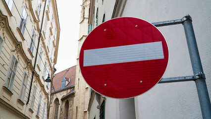 No entry road sign visible on a narrow street in an urban area with historic architecture during daylight
