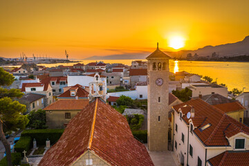 A picturesque view from the center of Vranjic, Croatia, at sunset, showcasing its charming Mediterranean streets, historic architecture, and the Adriatic Sea, creating a romantic coastal atmosphere