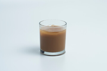 Ice coffee with milk in a transparent glass isolated on a white background.