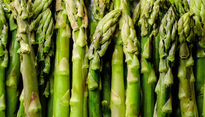 Fototapeta premium Detailed view of fresh asparagus spears, highlighting their tender tips and vibrant green color. Perfect for healthy food, salads, or vegetable concepts. Texture, background.