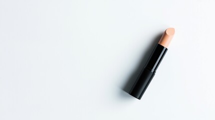 Black concealer stick with a neutral shade on white surface