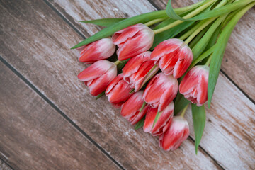 Bright red tulips arranged on rustic wooden surface in natural lighting