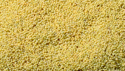 Repeating pattern of tiny couscous grains, emphasizing their uniform size and golden color. Ideal for Mediterranean cuisine or healthy food concepts. Texture, background.