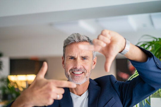 Businessman making finger frame at office