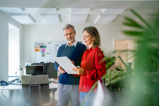 Business colleagues discussing in office using tablet pc - Powered by Adobe