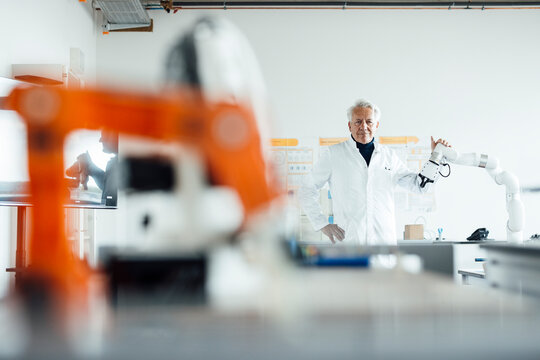 Senior engineer in laboratory with robotic equipment