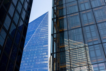 Dramatic perspective of commercial high-rises in The City, London, showcasing urban density, corporate expansion, and economic influence.