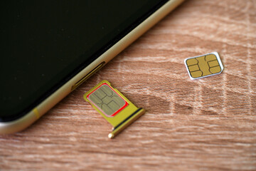 Set of color SIM cards near modern mobile phone background