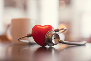 Red heart shape exercise ball with doctor physician's stethoscope on hospital background, hospital...