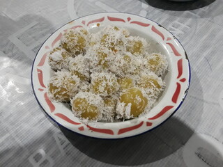 Sweet potato klepon with grated coconut in Indonesian traditional plate 