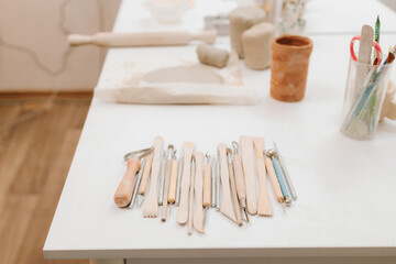 Set of craft sculpting tools on table in pottery workshop. Pottery gears for molding ceramics.