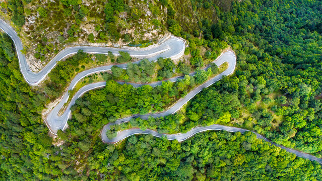 Aerial view of the winding road to Col de la Turini surrounded by lush greenery in Parc Naturel des Pr�Alpes d'Azur