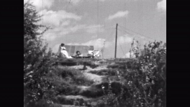 Family relaxing in summer countryside nature. Black white film. Abstract weekend of family vacation among trees in retro style. Relaxing outdoor leisure. Carefree holidays Vintage film. 1960s archive