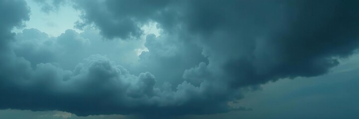 Fototapeta premium Heavy grey clouds engulf the sky with towering vertical growth, stormy, ominous