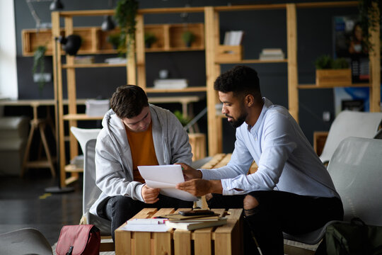 Young man with Down syndrome studyng with special educator teacher in special education classroom.