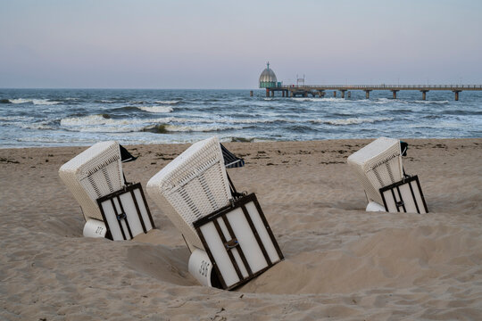 Beach chairs on the sandy shore of Zinnowitz, Usedom Island, with a view of the diving gondola and pier in Mecklenburg Western Pomerania, Germany