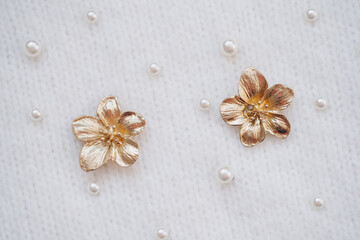 Elegant golden flower embellishments on a textured fabric background