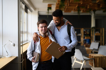 Young man with Down syndrome and his buddy with arms around his shoulders, walking down the school...
