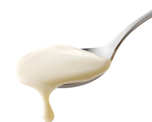 Creamy white sauce dripping from a metal spoon against a transparent background