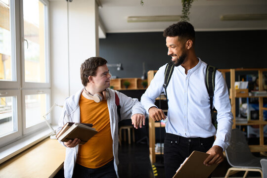 Young man with Down syndrome greeting his teacher in school.