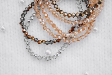 Colorful beaded bracelets displayed on a textured white surface during daylight