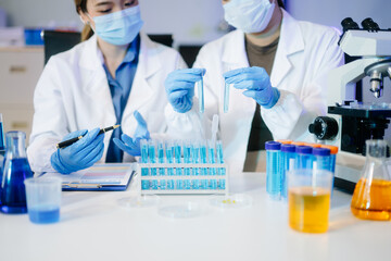 Fototapeta premium Young scientists conducting research investigations in a medical laboratory, a researcher in the foreground