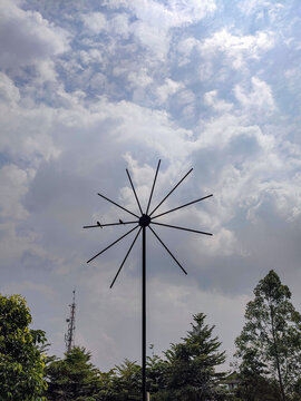 two birds perched on a unique garden lamp in the shape of a windmill