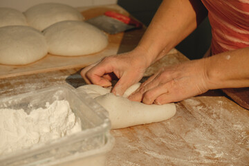 Kneading dough with care in a cozy bakery during golden hour, creating artisan bread for the community and spreading warmth through baking