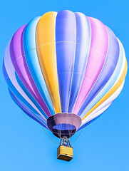 Fototapeta premium Colorful hot air balloon soars against a clear blue sky. Upward travel view
